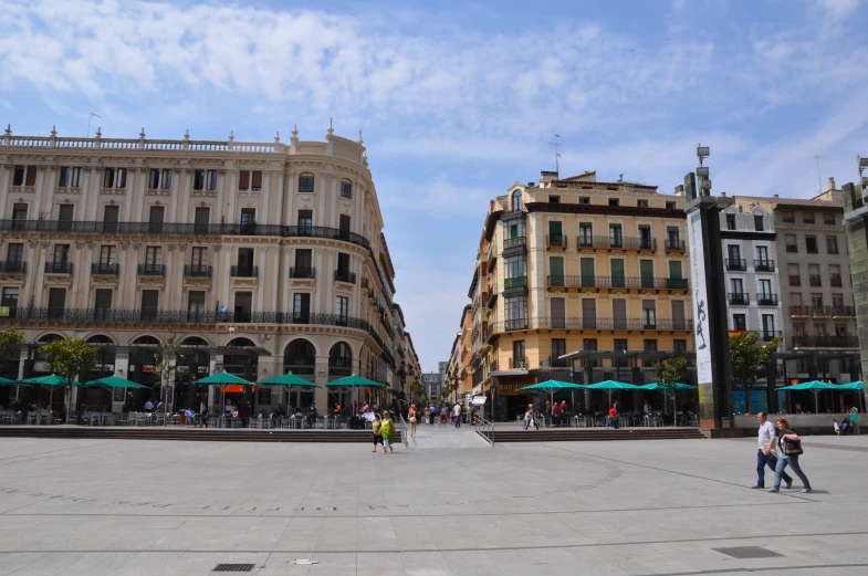 some people walking around a deserted square with umbrellas