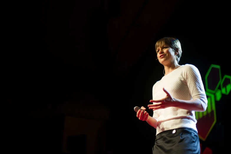 a woman is standing up while making a speech