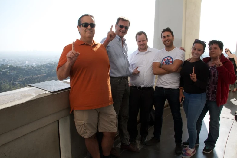 six men are standing together in front of a glass wall