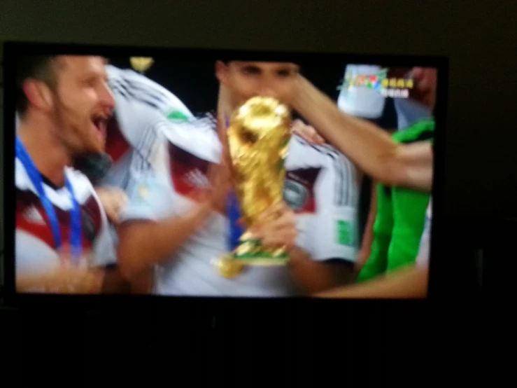 a television screen showing two soccer players in celetion