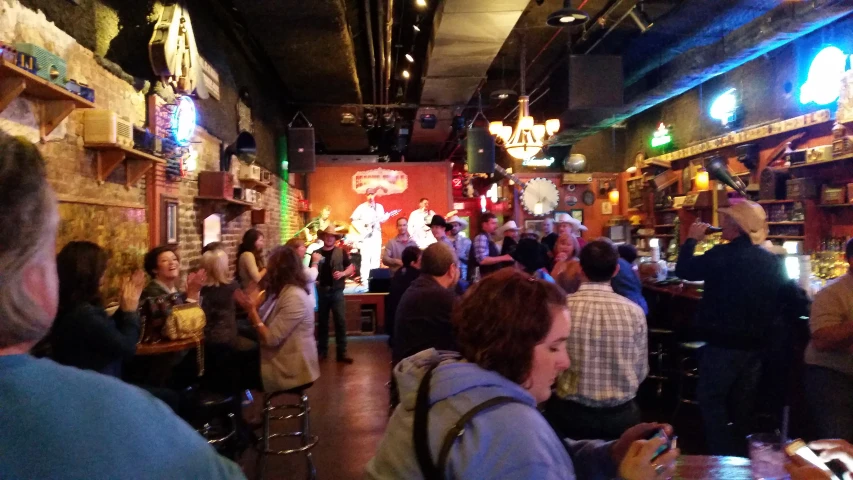 a crowd of people gathered in a bar for drinks