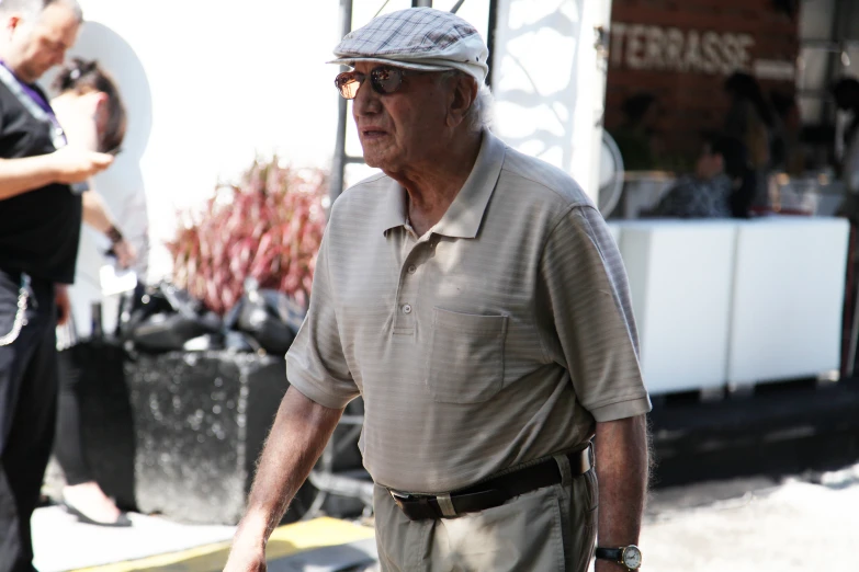 an old man in a hat walks by a building