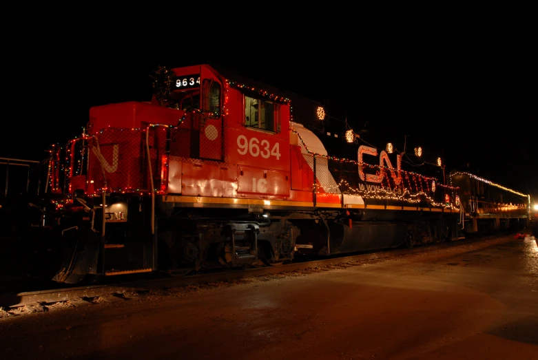 a train traveling down railroad tracks with a lot of lights on it