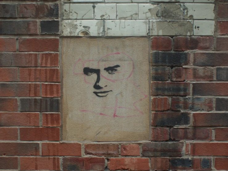 an old brick wall with graffiti on the face and other graffiti