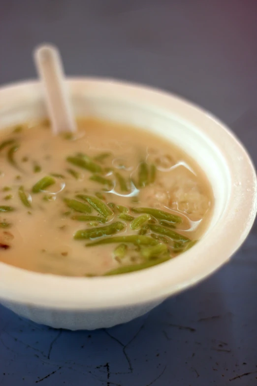 an old school soup bowl that is filled with vegetables and soup