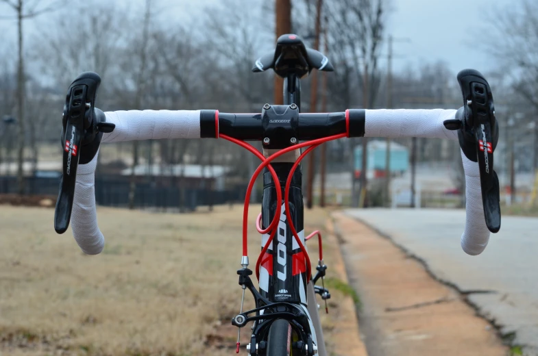 a bicycle parked next to the side of a road