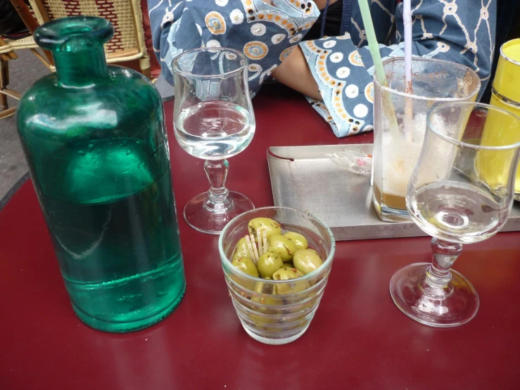 a red table topped with three glasses filled with liquid