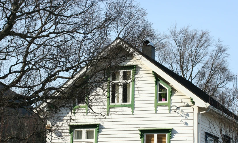 a wooden house sitting under a tree filled sky