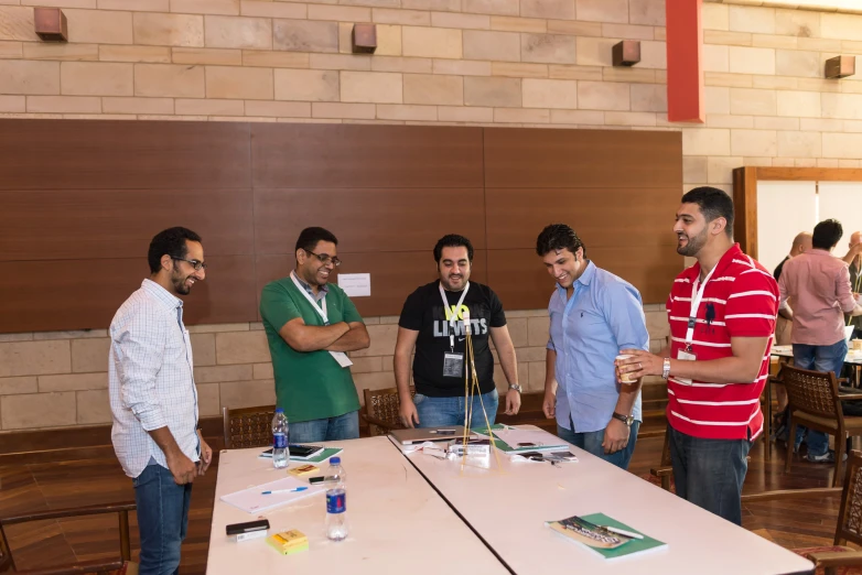 a group of men gathered in front of a table