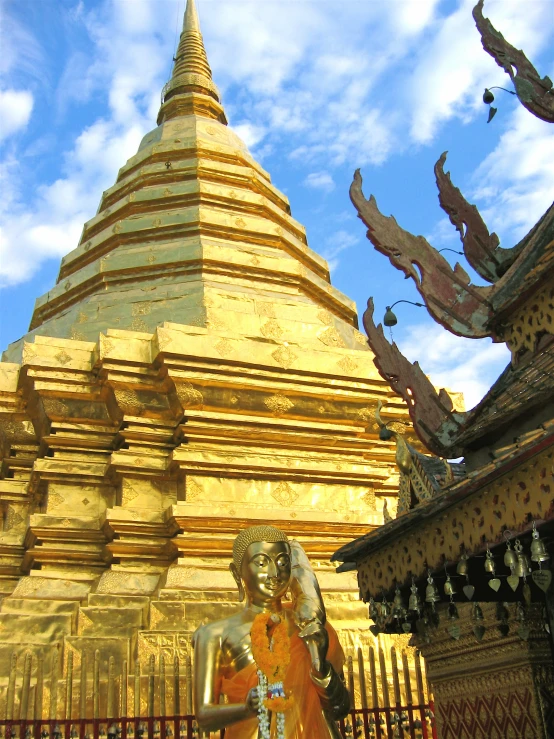 a statue in front of some golden pagodas