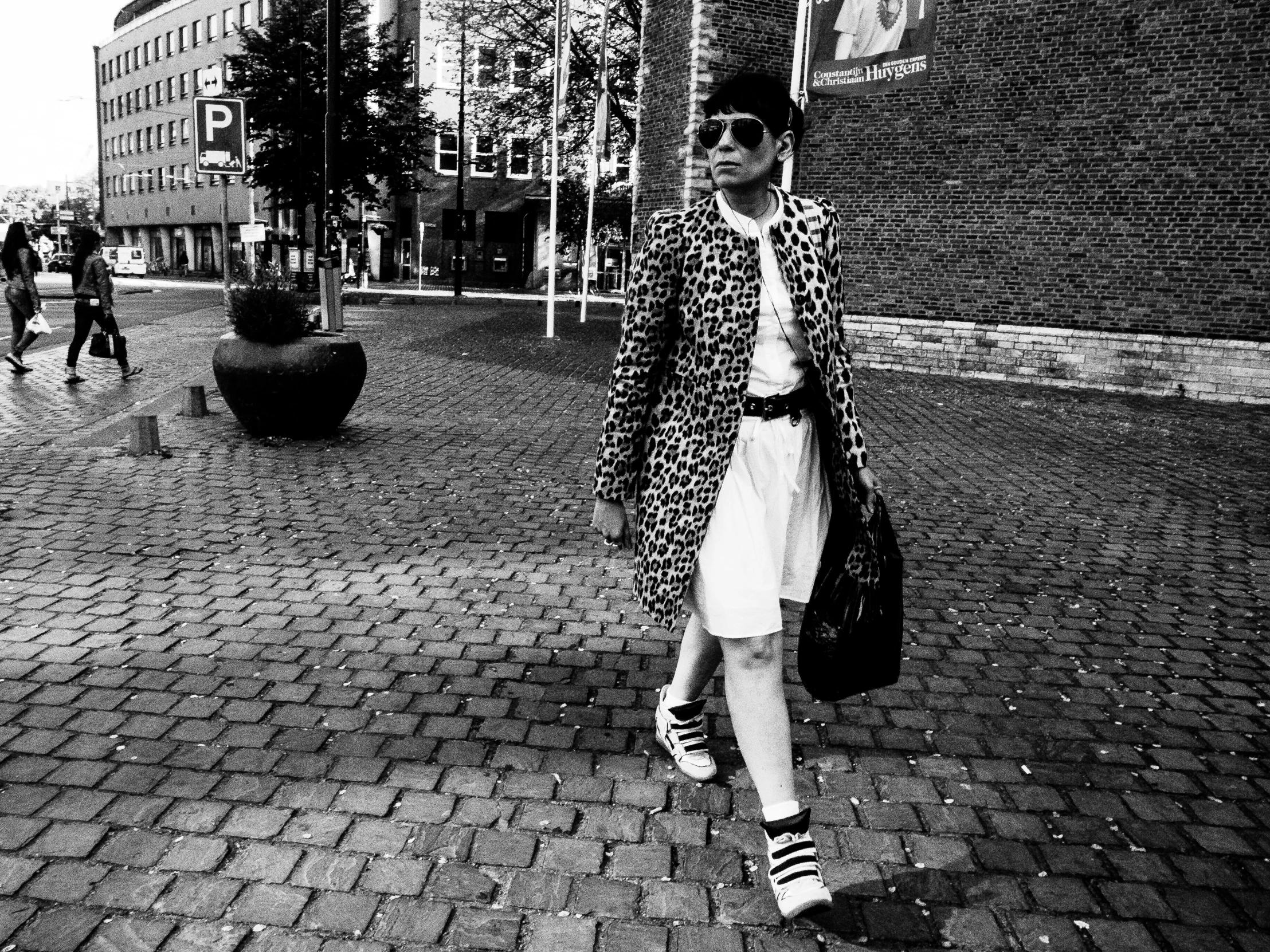 a young woman walking down a street next to buildings