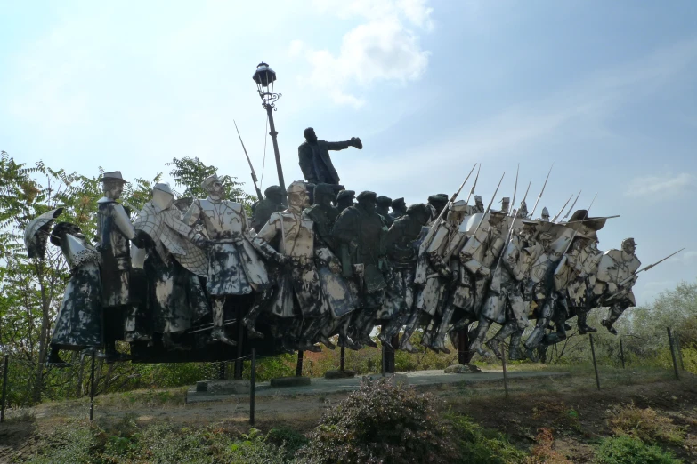 sculpture with two men holding up large group of cloths