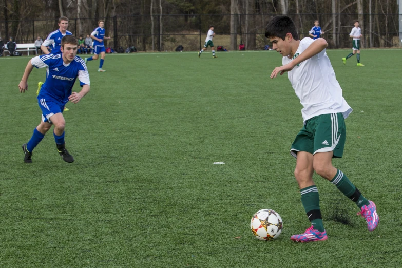 a couple of boys that are playing soccer in some grass