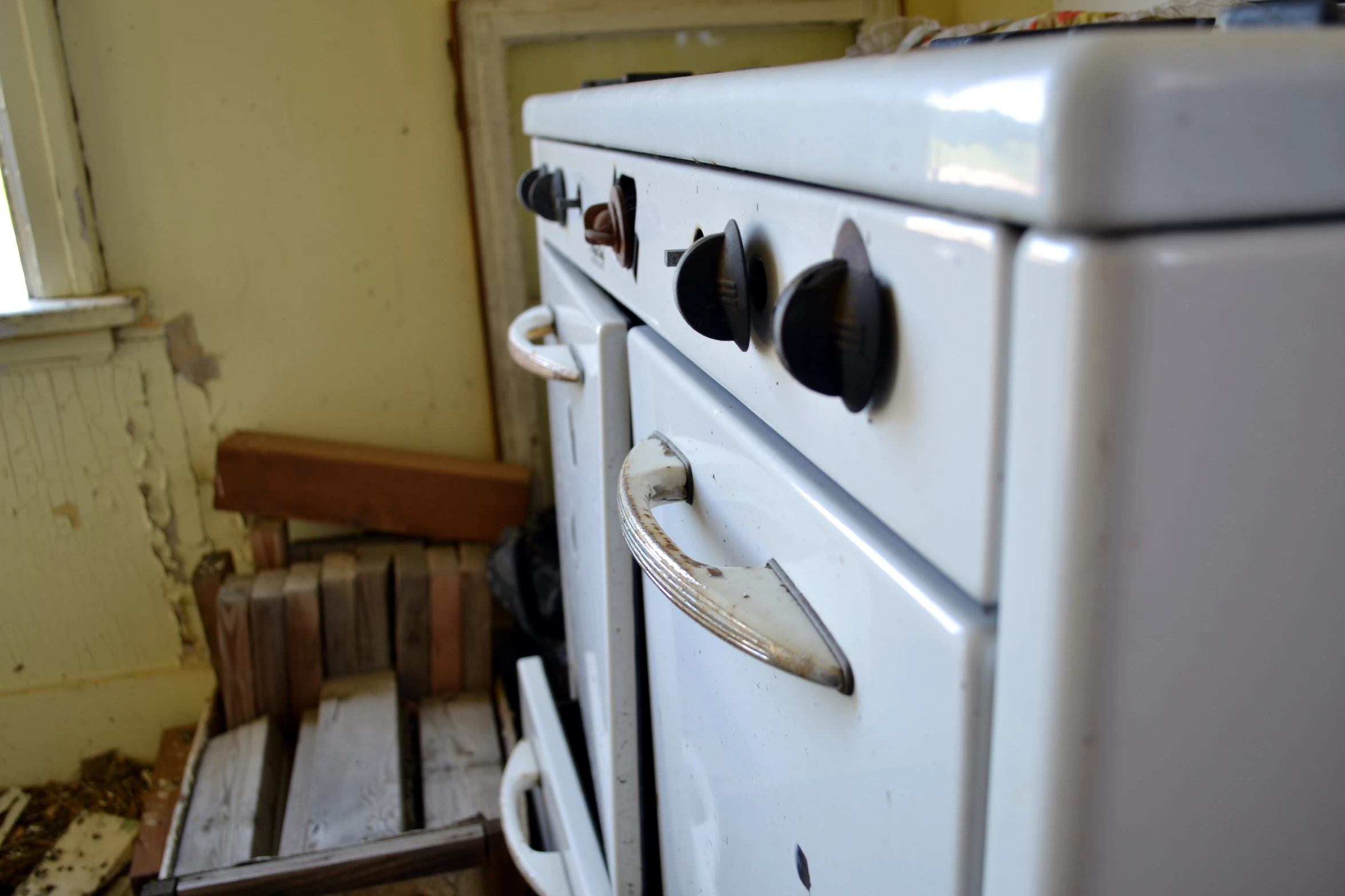 an old stove with rusted handles in an old kitchen