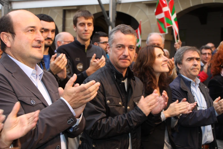 several men and women applauding during a press conference