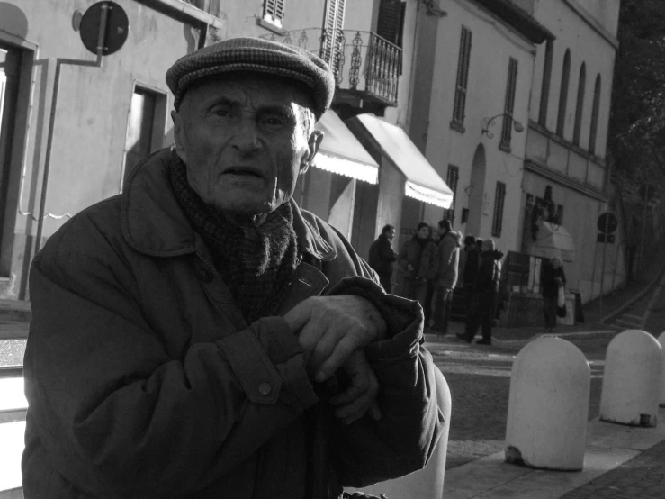 an old man standing on the side of a road