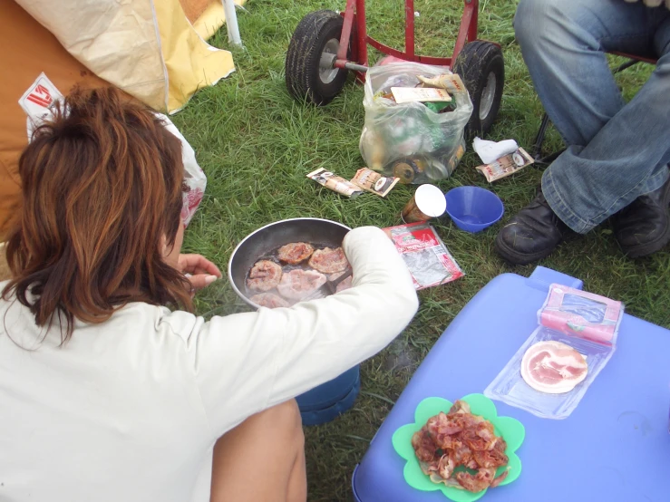 people are gathered in the grass to eat