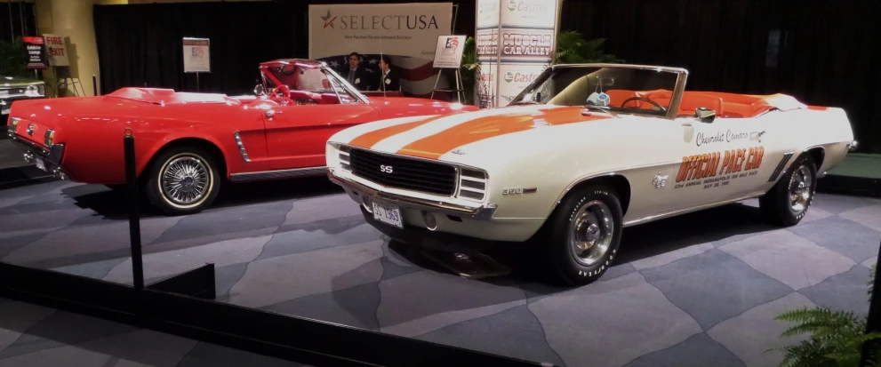 three different types of classic cars displayed at an auto show