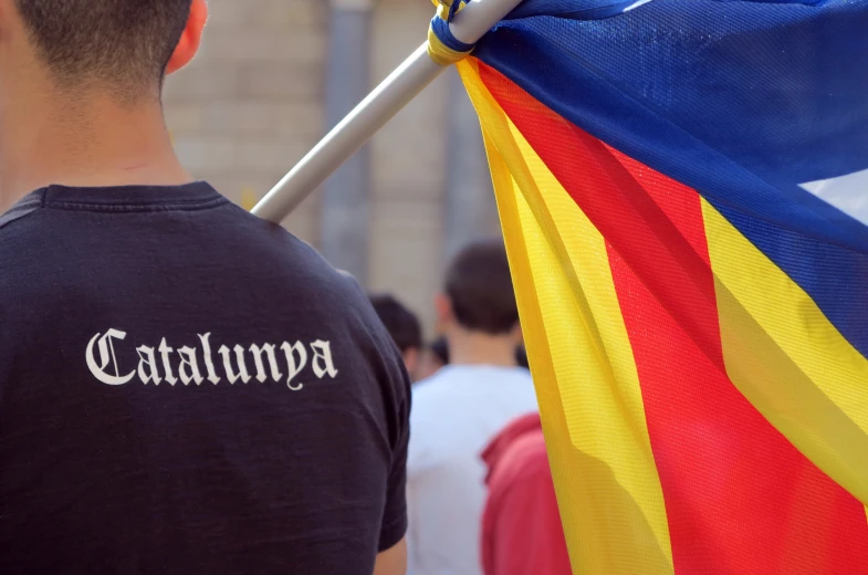 a man in black shirt holding flag of spain