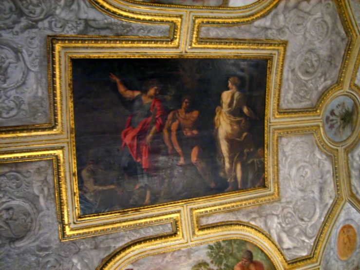 a painting hanging above some colorful paintings