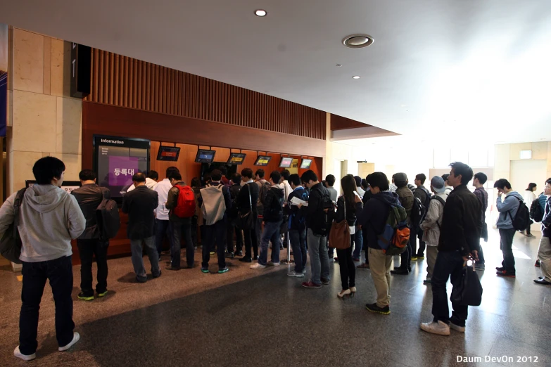 several people gather inside a building with their backs turned