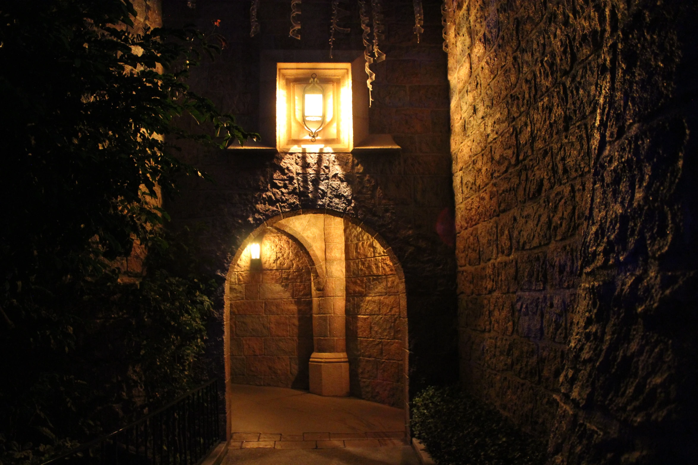 a stone wall with a small light at the end of it