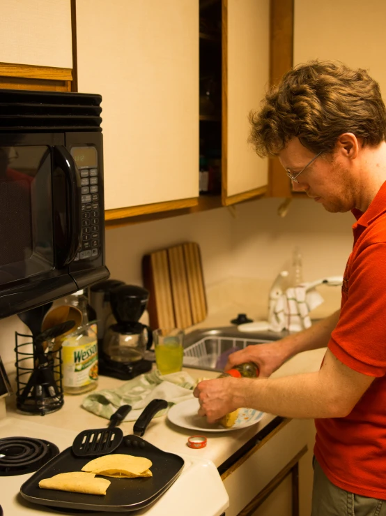 a man making sandwiches in front of the microwave