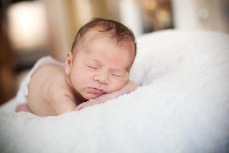 the sleeping baby is laying down on a blanket