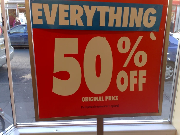 a sign that says everything 50 % off is displayed on a window