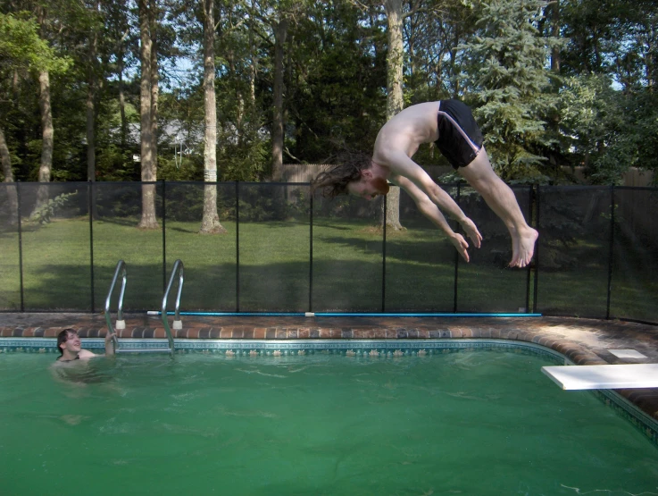 a man diving in to a pool that has no swimming