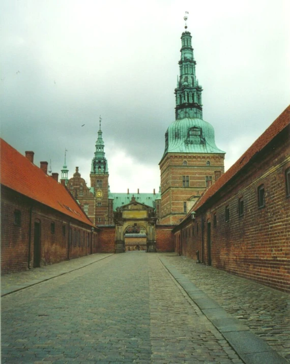 the view from an alley in a town with brick buildings