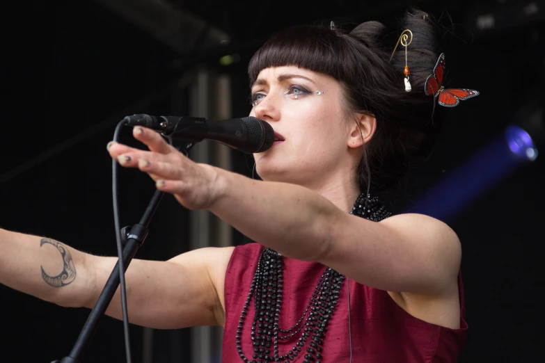 a young woman singing with a microphone on stage