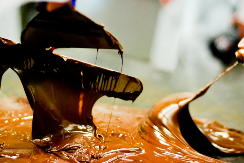 someone is pouring melted caramel into the top of a dish