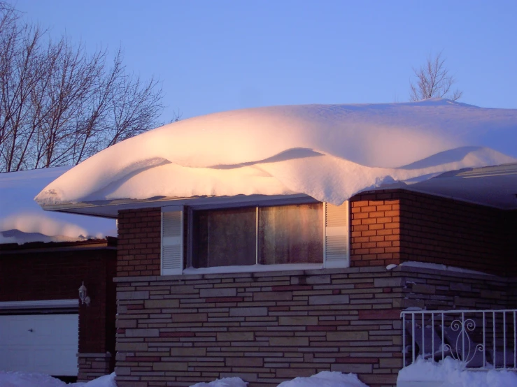 a roof covered with snow in front of a house