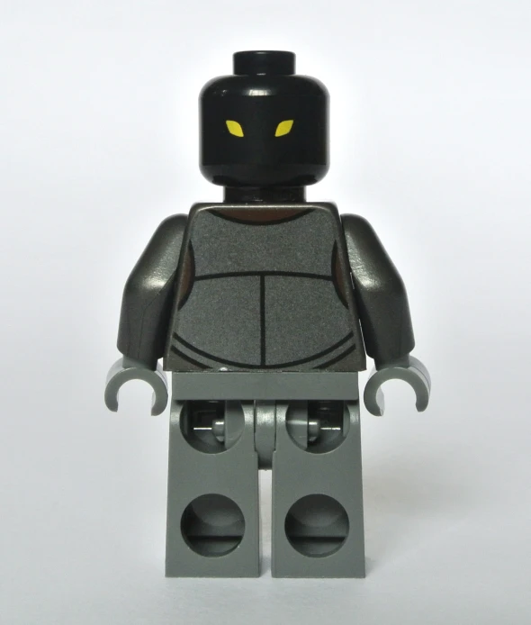 a gray and yellow toy figure with two hands on top of it