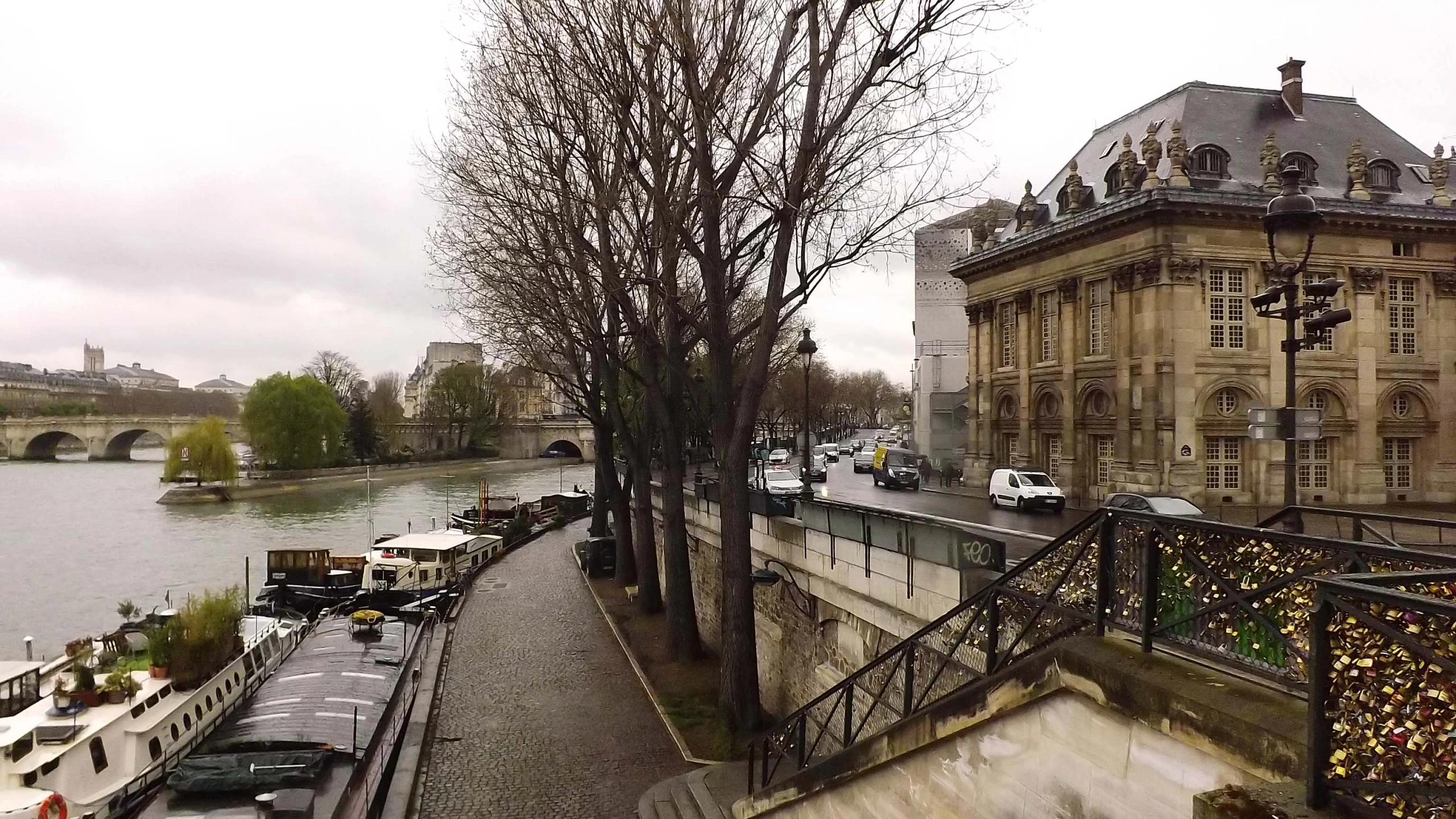 a river runs beside a city street and bridge