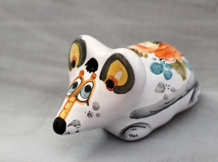 a hand painted white ceramic animal that is on a table