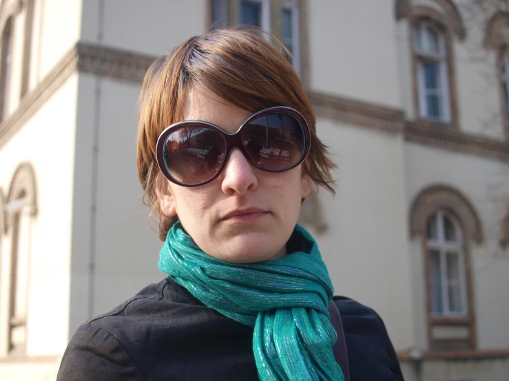a woman wearing sun glasses and a green scarf