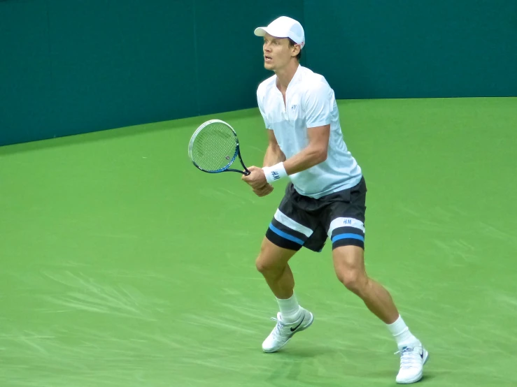 man holding a tennis racquet standing on a tennis court