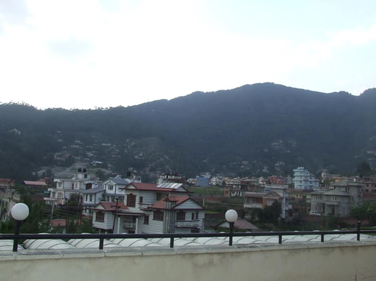 a hillside area with mountains and buildings in the background