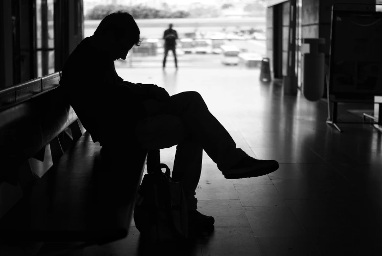 a man is waiting by his luggage in the dark