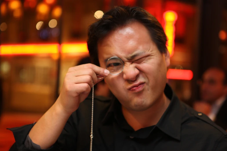 a man with glasses on his face is holding a chain