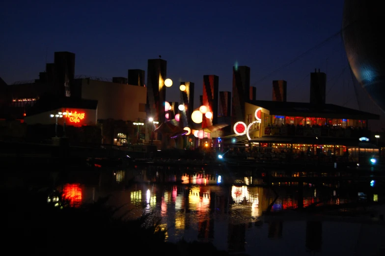 the lights shine on the building beside the water