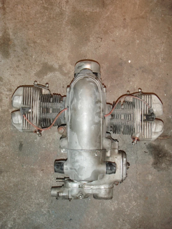 an old silver airplane engine with two motorbikes