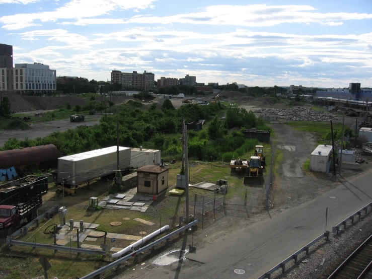 a dirt field next to a long train track