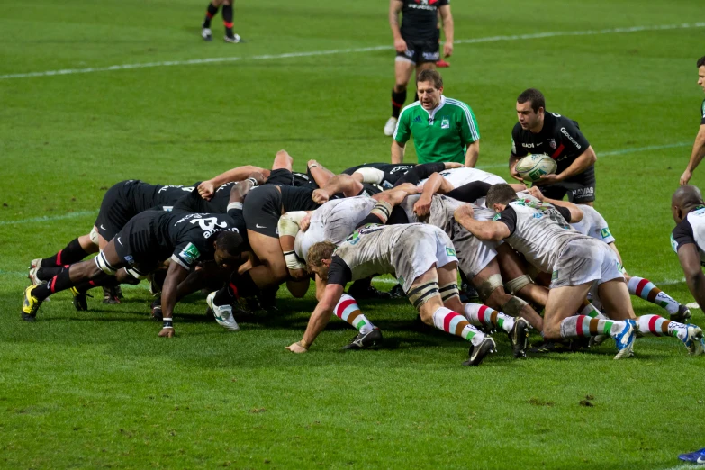 a group of rugby players huddle together for a hug