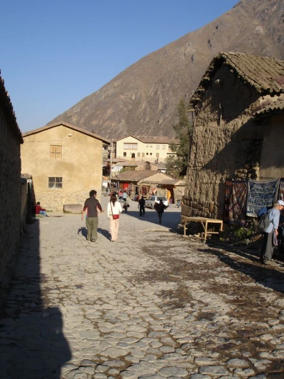 several people walk in a cobblestone street