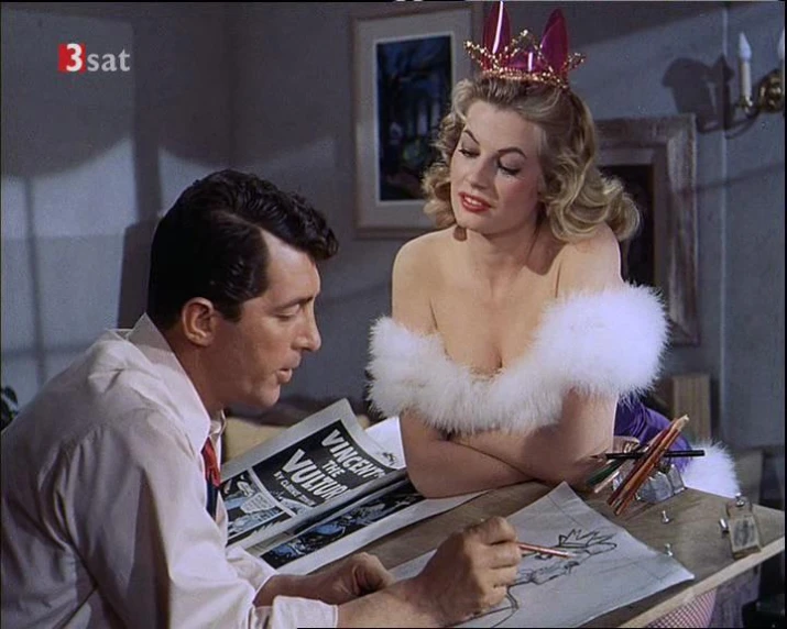 a man and a woman sitting at a desk looking through the paper