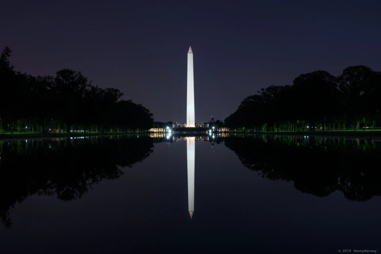 a tower on top of a body of water at night