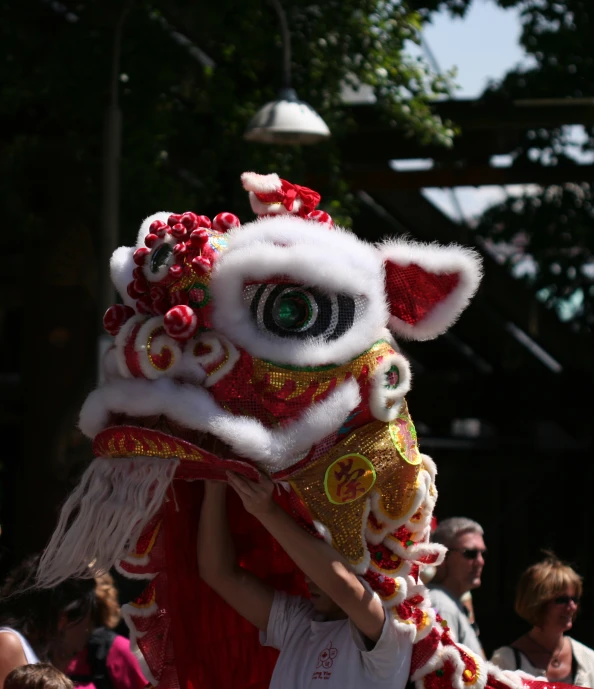 a woman is holding a dragon costume over her face